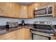 Kitchen with stainless steel appliances, hardwood cabinets, and granite countertops at 17912 E Milan Pl, Aurora, CO 80013