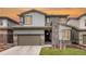 Two-story home boasts a stylish design with stone accents and a neutral color palette, set against a vibrant sunset sky at 533 Red Thistle Dr, Highlands Ranch, CO 80126