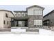 Exterior elevation features stone accents, snow-covered ground, and covered porch with sliding doors at 533 Red Thistle Dr, Highlands Ranch, CO 80126