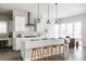 Bright kitchen features white cabinets, stainless steel appliances, and stylish pendant lighting over the island with seating at 533 Red Thistle Dr, Highlands Ranch, CO 80126