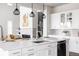 Modern kitchen with white cabinets, stylish lighting, large island, and stainless steel appliances at 533 Red Thistle Dr, Highlands Ranch, CO 80126