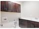 Spacious laundry room features dark wood cabinets, white countertops, and a utility sink at 533 Red Thistle Dr, Highlands Ranch, CO 80126