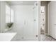 Bathroom shower stall with a glass door and a white tiled interior, next to stylish patterned floors at 533 Red Thistle Dr, Highlands Ranch, CO 80126