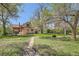 Backyard view with a green lawn, mature trees, and walkway at 5475 W 1St Ave, Lakewood, CO 80226