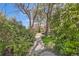 Scenic backyard view with lush greenery, mature trees and a charming sidewalk at 5475 W 1St Ave, Lakewood, CO 80226