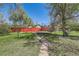 An outdoor backyard features grass, a trampoline, and a red wooden fence at 5475 W 1St Ave, Lakewood, CO 80226