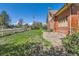 Classic brick house with a well-kept lawn, picket fence, and mature trees offering plenty of shade at 5475 W 1St Ave, Lakewood, CO 80226