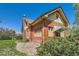 Brick house with ample windows, a vintage awning and well-maintained landscaping at 5475 W 1St Ave, Lakewood, CO 80226