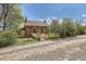 Charming brick home featuring a welcoming ramp with mature trees adding to its curb appeal at 5475 W 1St Ave, Lakewood, CO 80226