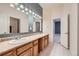 Bright bathroom features double sinks, wood cabinets, and neutral tile flooring at 1272 Nightfire Cir, Castle Rock, CO 80104
