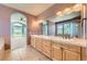Bathroom featuring double sinks, tile floors, and archway leading to bedroom at 1272 Nightfire Cir, Castle Rock, CO 80104