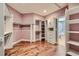 Spacious walk-in closet with wood floors, built-in shelving and storage, and open doorway to bathroom at 1272 Nightfire Cir, Castle Rock, CO 80104