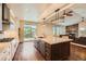 Open kitchen featuring wood floors, a large island with granite countertops, and mountain views through sliding glass doors at 1272 Nightfire Cir, Castle Rock, CO 80104