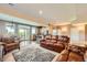 Open-concept living room with a leather sofa, area rug, and access to the kitchen and outdoor patio at 1272 Nightfire Cir, Castle Rock, CO 80104