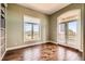 Room with hardwood floors, natural lighting from large window, and arched doorway leading to stone patio at 1272 Nightfire Cir, Castle Rock, CO 80104