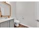 Clean bathroom with a vanity, a framed mirror, and a toilet at 5255 Memphis St # 318, Denver, CO 80239