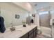 Bright bathroom featuring a double sink vanity, tiled shower, and a soaking tub at 15646 W Floyd Dr, Morrison, CO 80465