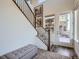 Bright entryway featuring wood floors, a staircase with black metal railings and a bench at 15646 W Floyd Dr, Morrison, CO 80465