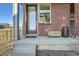Close up view of the front door, with a small porch area and brick facade at 15646 W Floyd Dr, Morrison, CO 80465