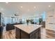 Open-concept layout, seamlessly connecting the kitchen, living, and dining areas with wood floors and great lighting at 15646 W Floyd Dr, Morrison, CO 80465