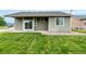 Back of house with green grass, patio and sliding glass doors at 268 Naples St, Firestone, CO 80520