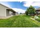 Large green backyard with well manicured lawn and lush green trees at 268 Naples St, Firestone, CO 80520