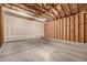 Spacious two-car garage with high ceilings, unfinished walls, and a side utility door at 268 Naples St, Firestone, CO 80520