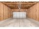 Spacious two-car garage with high ceilings, unfinished walls, and an automatic garage door opener at 268 Naples St, Firestone, CO 80520