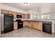 Bright kitchen features tile floors, black appliances, and wooden cabinets at 268 Naples St, Firestone, CO 80520