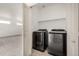 Modern laundry room with washer, dryer, and shelving at 268 Naples St, Firestone, CO 80520