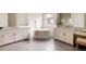 Bright bathroom features double vanity, soaking tub, and a window view at 6608 S White Crow Ct, Aurora, CO 80016