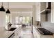 Well-appointed kitchen with a large island, quartz countertops, and adjoining dining area with bright windows at 6608 S White Crow Ct, Aurora, CO 80016