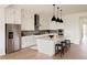 Bright, open kitchen with stainless steel appliances, island with counter seating, and modern pendant lighting at 6608 S White Crow Ct, Aurora, CO 80016