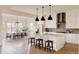 Stylish open kitchen with sleek white cabinets, a large center island, and a spacious dining area at 6608 S White Crow Ct, Aurora, CO 80016