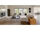 Bright living room features a cozy fireplace, large windows, and stylish, neutral furniture at 6608 S White Crow Ct, Aurora, CO 80016