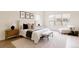 Serene main bedroom featuring a comfortable bed, bench, and ample natural light from the windows at 6608 S White Crow Ct, Aurora, CO 80016