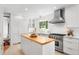 White kitchen features a butcher block island, stainless steel appliances, and plenty of natural light at 160 Bristlecone Way, Boulder, CO 80304