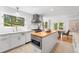 White kitchen featuring a butcher block island, stainless steel range hood and light tile backsplash at 160 Bristlecone Way, Boulder, CO 80304