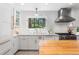 Kitchen featuring a large stainless steel range hood, light backsplash and countertops and a butcher block island at 160 Bristlecone Way, Boulder, CO 80304