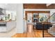 Open-concept living room with hardwood floors, exposed beams, a brick fireplace, and seamless flow to the kitchen at 160 Bristlecone Way, Boulder, CO 80304