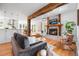 Open-concept living room with hardwood floors, a brick fireplace, and seamless flow to the kitchen and dining area at 160 Bristlecone Way, Boulder, CO 80304
