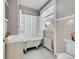 Charming bathroom with a clawfoot tub, classic tile, and a window for natural light at 215 E 11Th Ave # D8, Denver, CO 80203