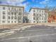 Classic exterior view of a white apartment building with mature trees near a city street at 215 E 11Th Ave # D8, Denver, CO 80203