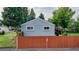 Back exterior view showcasing the house with its fenced backyard and gravel area at 103 S Zenobia St, Denver, CO 80219