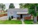 Back exterior featuring a blue-painted facade, small covered porch, and a fenced-in yard with green lawn at 103 S Zenobia St, Denver, CO 80219