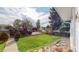 Charming home with a spacious front yard featuring mature trees and lush green lawn at 103 S Zenobia St, Denver, CO 80219