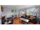 Comfortable living room with hardwood floors, leather seating, and an open layout with a view to the kitchen at 103 S Zenobia St, Denver, CO 80219