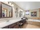 Bright bathroom featuring double sinks, a soaking tub, and decorative wall accents at 5481 E 117Th Ave, Thornton, CO 80233