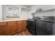 Functional laundry room with wooden cabinets, ample counter space, and modern washer/dryer at 5481 E 117Th Ave, Thornton, CO 80233