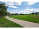 Scenic park view featuring a walking path and expansive green space under a partly cloudy sky at 5481 E 117Th Ave, Thornton, CO 80233